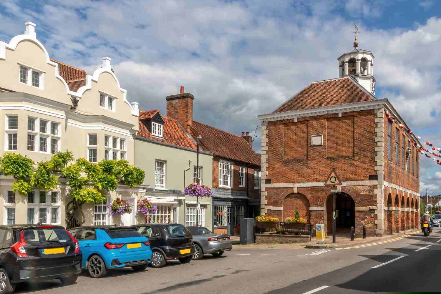 The red-brick Market Hall at the end of Old Amersham's high street, with rendered and tiled buildings alongside.