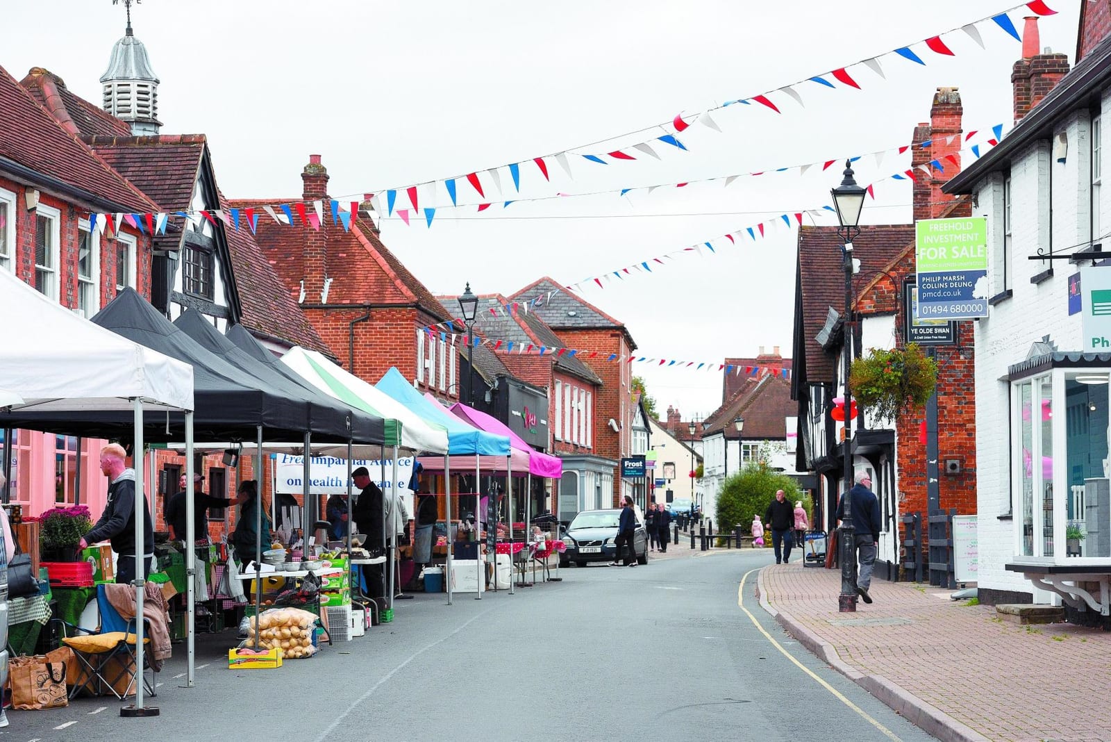 Market stalls and bunting on Burnham High Street, with brick and timbered buildings behind.