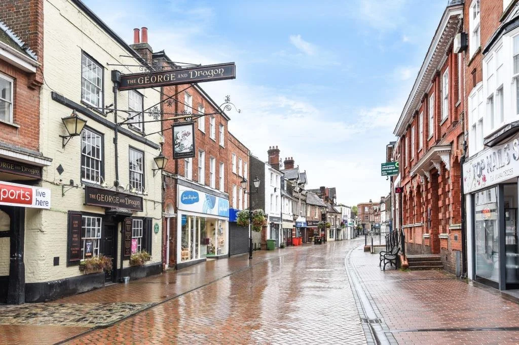 Chesham High Street after rain, with the George and Dragon pub sign hanging in the foreground.