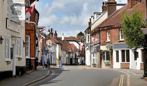 Great Missenden High Street hung with flags and bunting, looking down between the shops.
