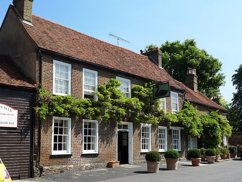 An old brick and timber village pub with wisteria growing across the front, in one of the villages by Heathrow.