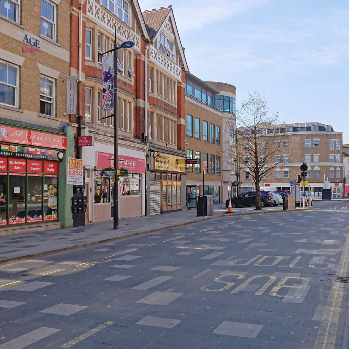 Shops and modern office blocks along a street in Slough town centre.