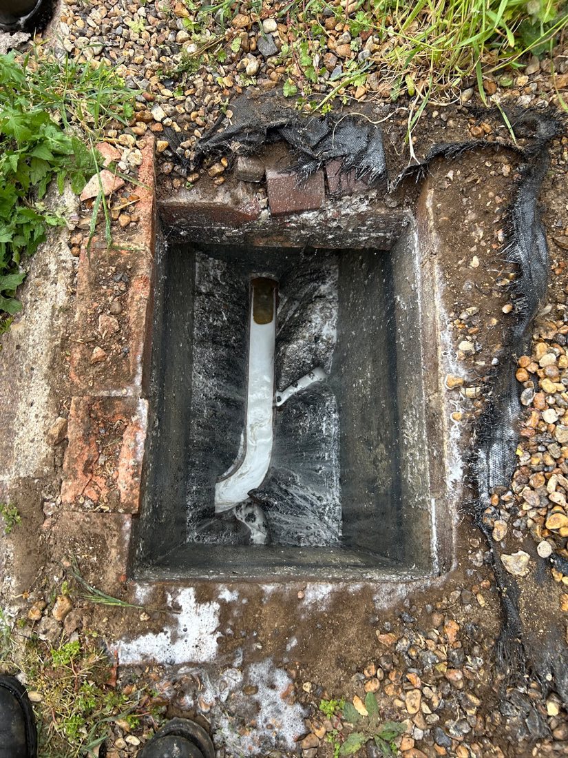 An inspection chamber cleaned out with the pipework now visible and clear.