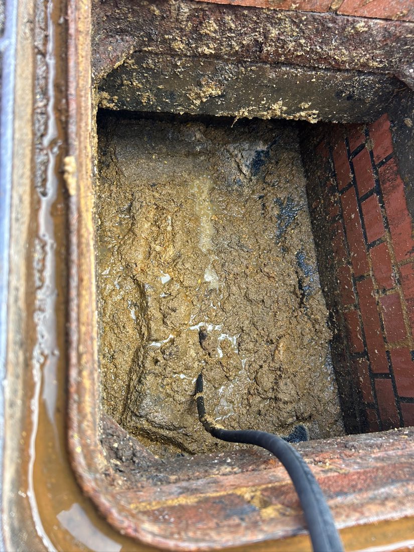 An inspection chamber completely filled with thick, set yellow fat and grease.