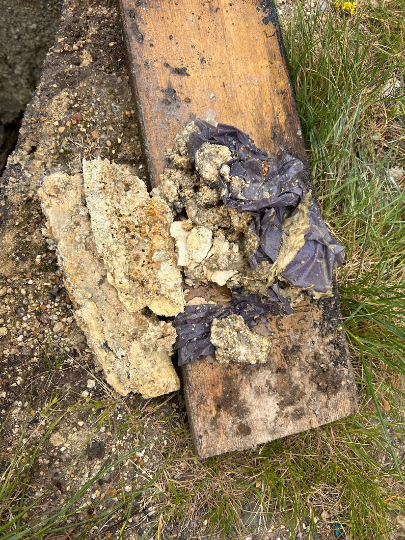 Chunks of rock-hard fat and wipes broken out of a pipe and laid on a board.