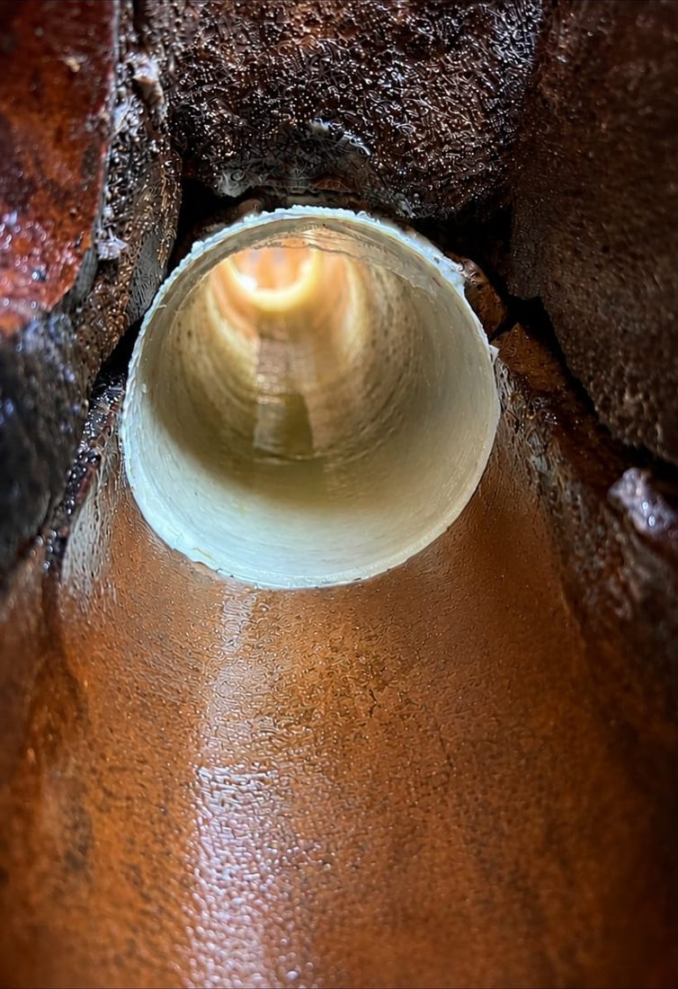 CCTV still of a cured patch liner seated inside a broken clay drain pipe, forming a smooth new bore through the damaged section
