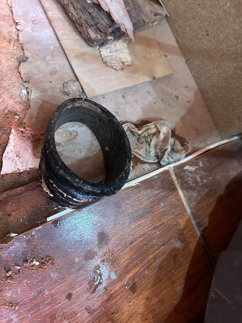 A cut-out section of cast iron pipe almost completely closed up with heavy internal scale.